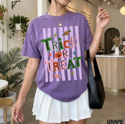 Person wearing a purple 'Trick or Treat' shirt in an indoor setting