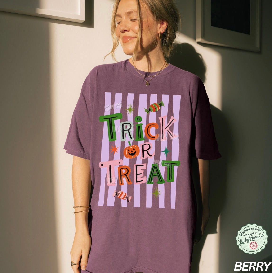 Person wearing a purple 'Trick or Treat' t-shirt against a neutral wall.