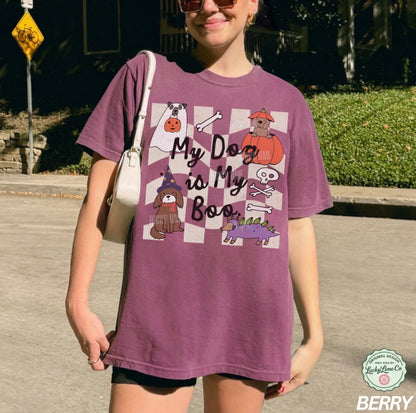 Person wearing a purple t-shirt with a graphic design, standing outdoors.