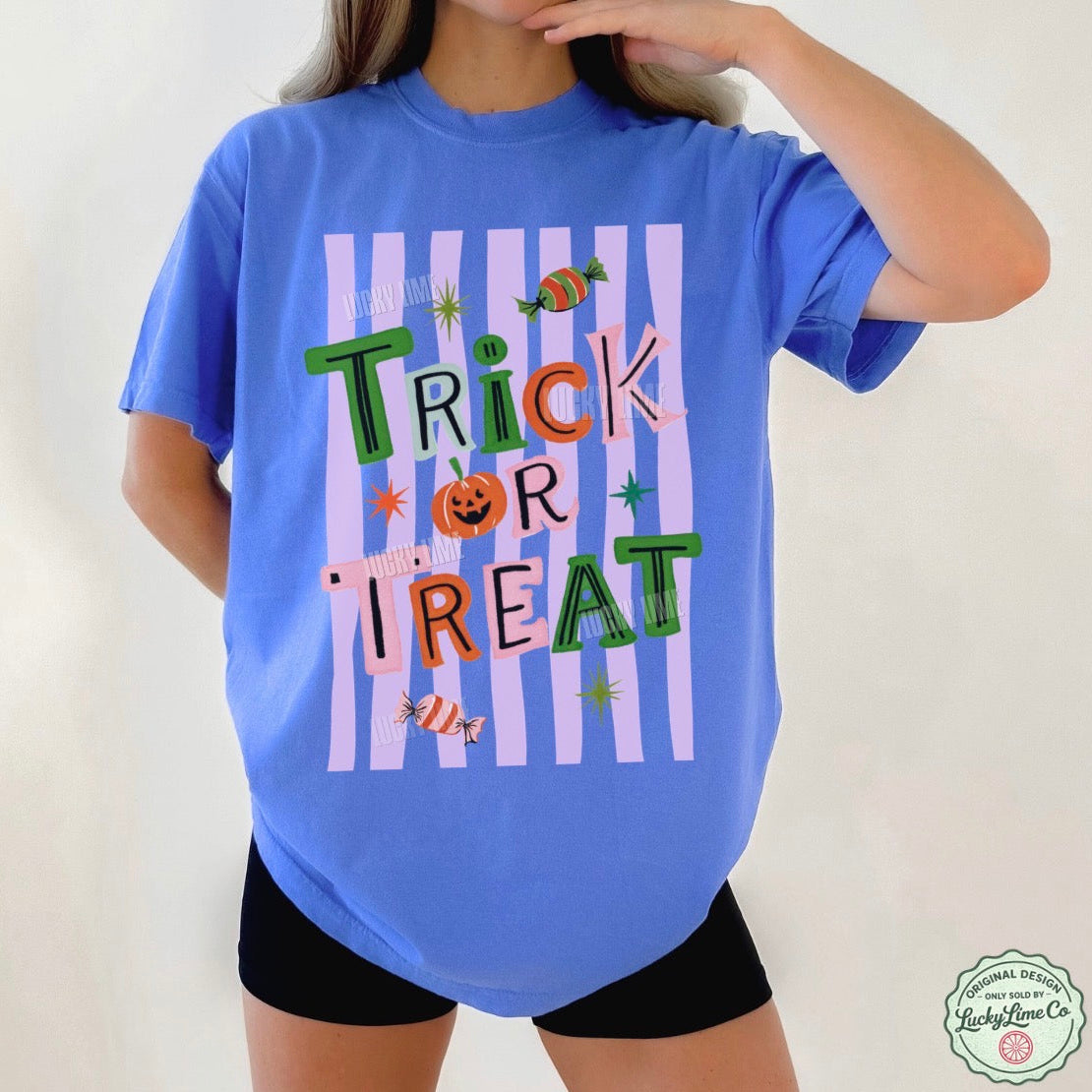 Person wearing a blue t-shirt with 'Trick or Treat' text and Halloween graphics on a plain background.