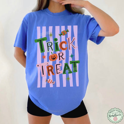 Person wearing a blue t-shirt with 'Trick or Treat' text and Halloween graphics on a plain background.
