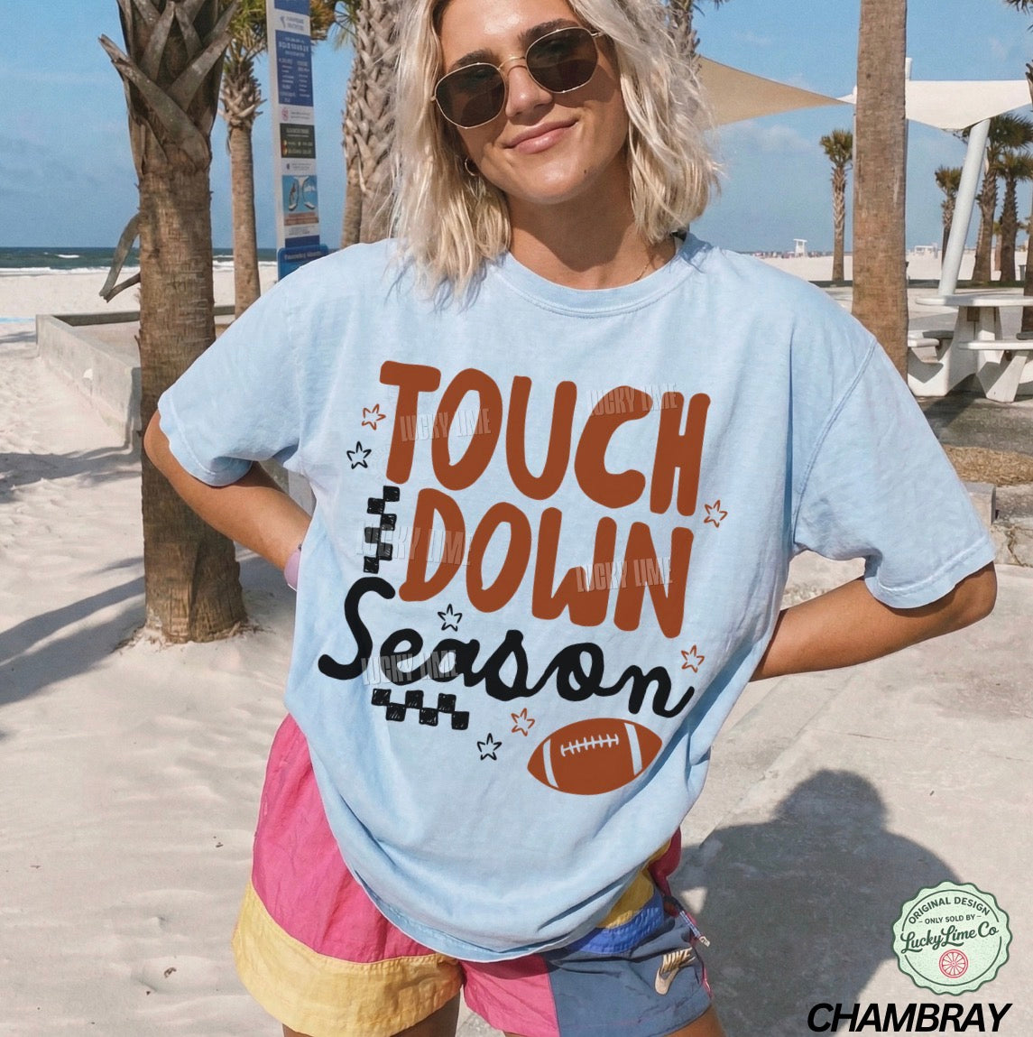 Person wearing a 'Touchdown Season' t-shirt on a beach