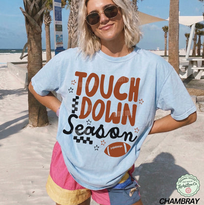 Person wearing a 'Touchdown Season' t-shirt on a beach