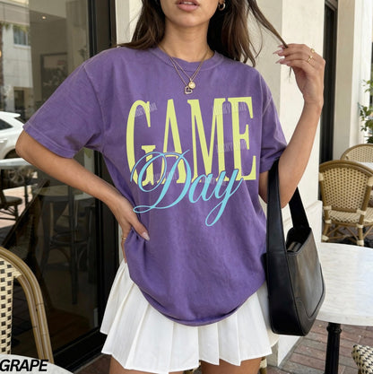 Woman wearing a purple tshirt with the words “Game Day”