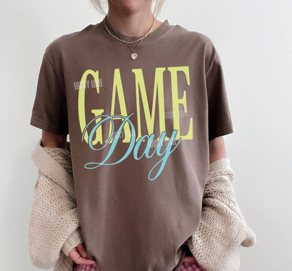 Woman wearing a brown tshirt with the words “Game Day”