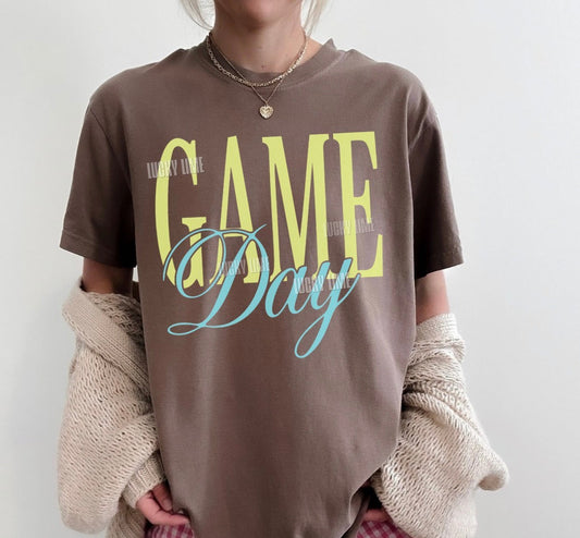 Woman wearing a brown tshirt with the words “Game Day”
