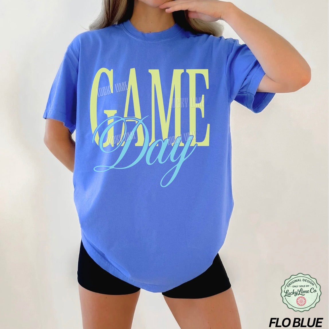 Woman wearing a bright blue tshirt with the words “Game Day” on a white background