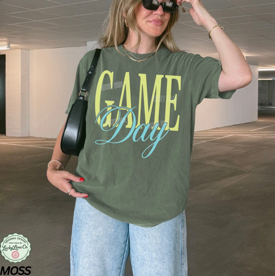 Woman wearing a moss colored tshirt with the words “Game Day”
