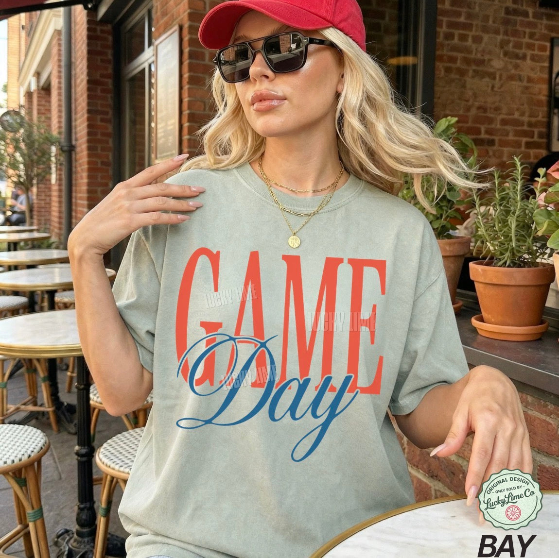 Woman wearing a 'Game Day' t-shirt outdoors.