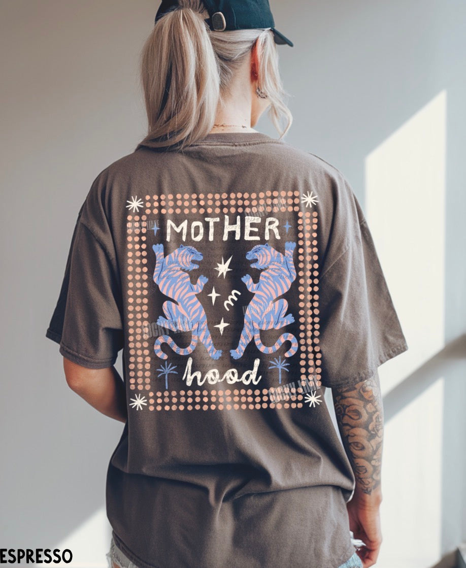 Person wearing a brown t-shirt with 'MOTHER hood' design on the back, standing in a well-lit room.