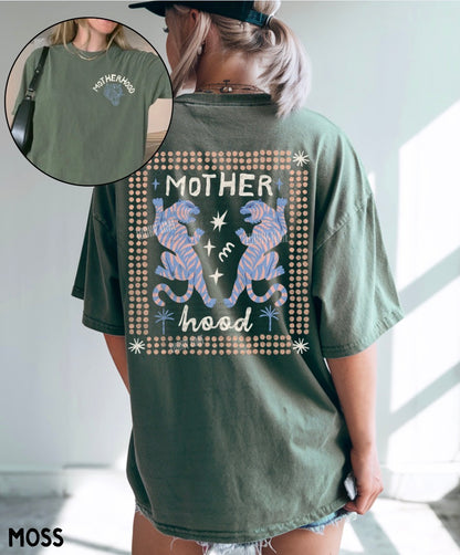 Person wearing a green t-shirt with 'Motherhood' design and inset showing text.