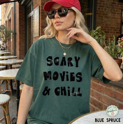 Woman wearing a green t-shirt with 'Scary Movies & Chill' text, sitting outdoors.