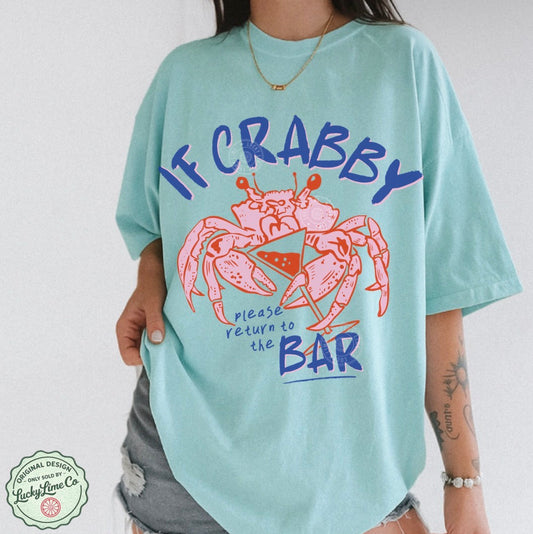 Person wearing a light blue t-shirt with a crab graphic and text on a white background