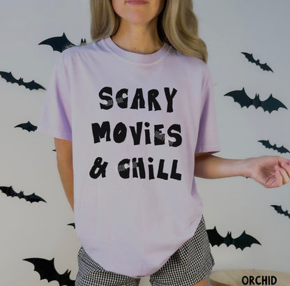 Person wearing a 'Scary Movies & Chill' t-shirt with Halloween-themed background