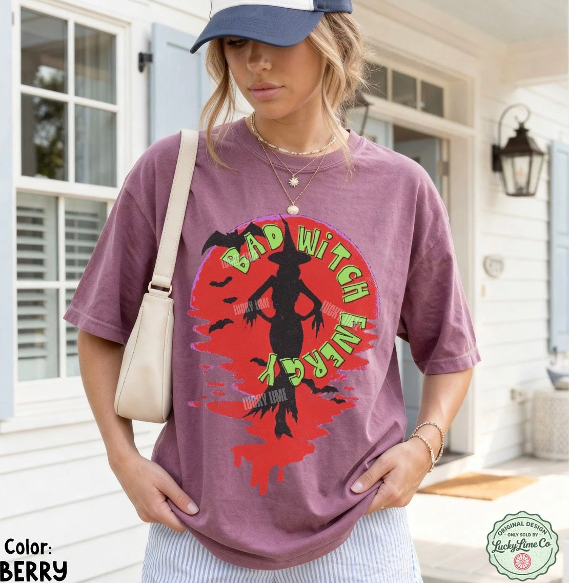 Woman wearing a purple t-shirt with a graphic design and text, standing outdoors.