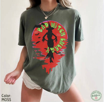 Person wearing a green t-shirt with a graphic design and text on a plain background