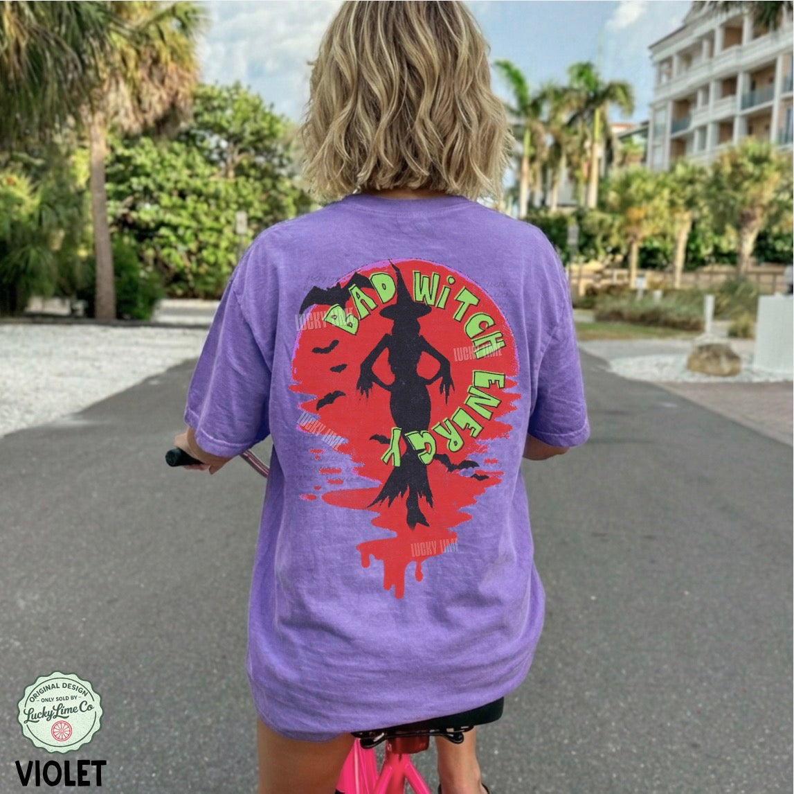 Person wearing a purple t-shirt with a colorful graphic on the back, standing outdoors.