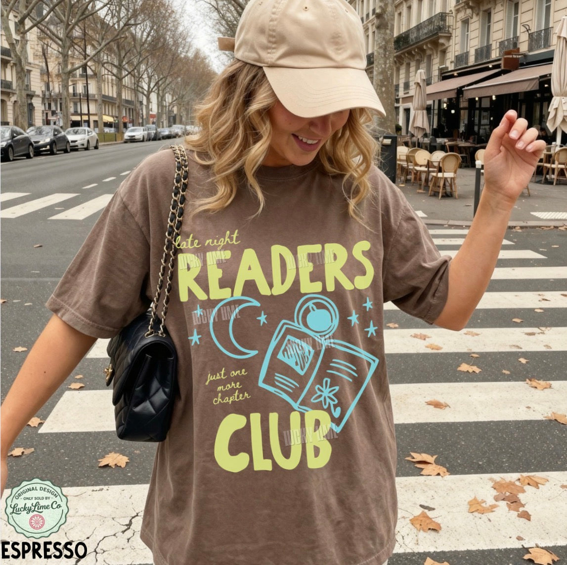 Woman wearing a 'Late Night Readers Club' t-shirt on a city street.