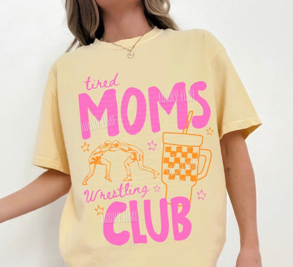 Yellow t-shirt with pink text 'tired MOMS Wrestling CLUB' on a white background
