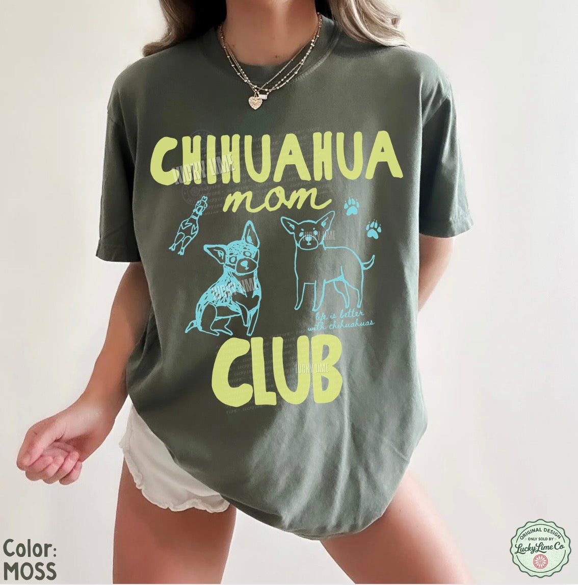 Person wearing a green t-shirt with 'Chihuahua mom club' text and graphics on a plain background