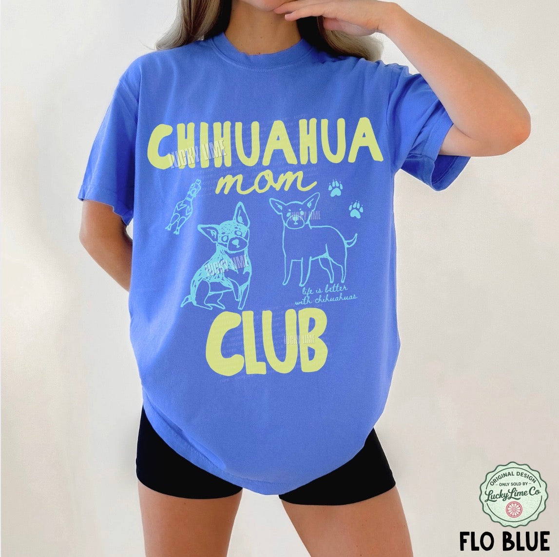 Person wearing a blue t-shirt with 'Chihuahua Mom Club' text and graphics on a white background