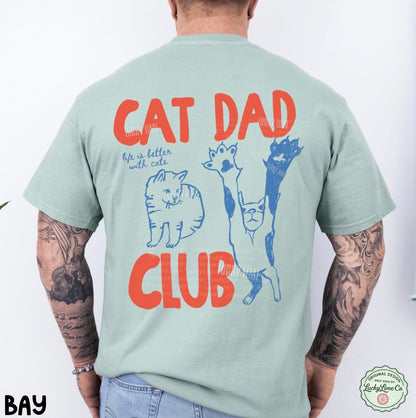 Person wearing a light green t-shirt with 'Cat Dad Club' text and cat illustrations on the back.