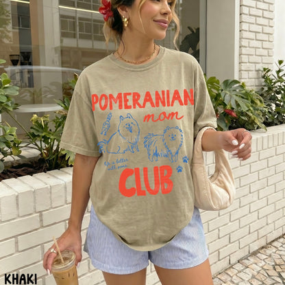 Woman wearing a 'Pomeranian mom club' t-shirt standing outdoors.
