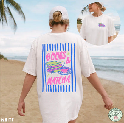 Person wearing a white t-shirt with 'Books & Matcha' design on a beach.