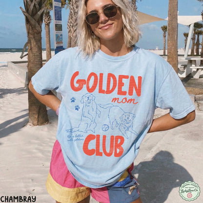 Person wearing a 'Golden Mom Club' t-shirt on a beach