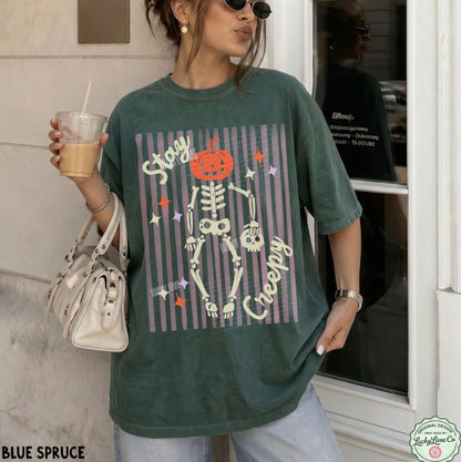 Person wearing a green t-shirt with a skeleton design and text, holding a drink.