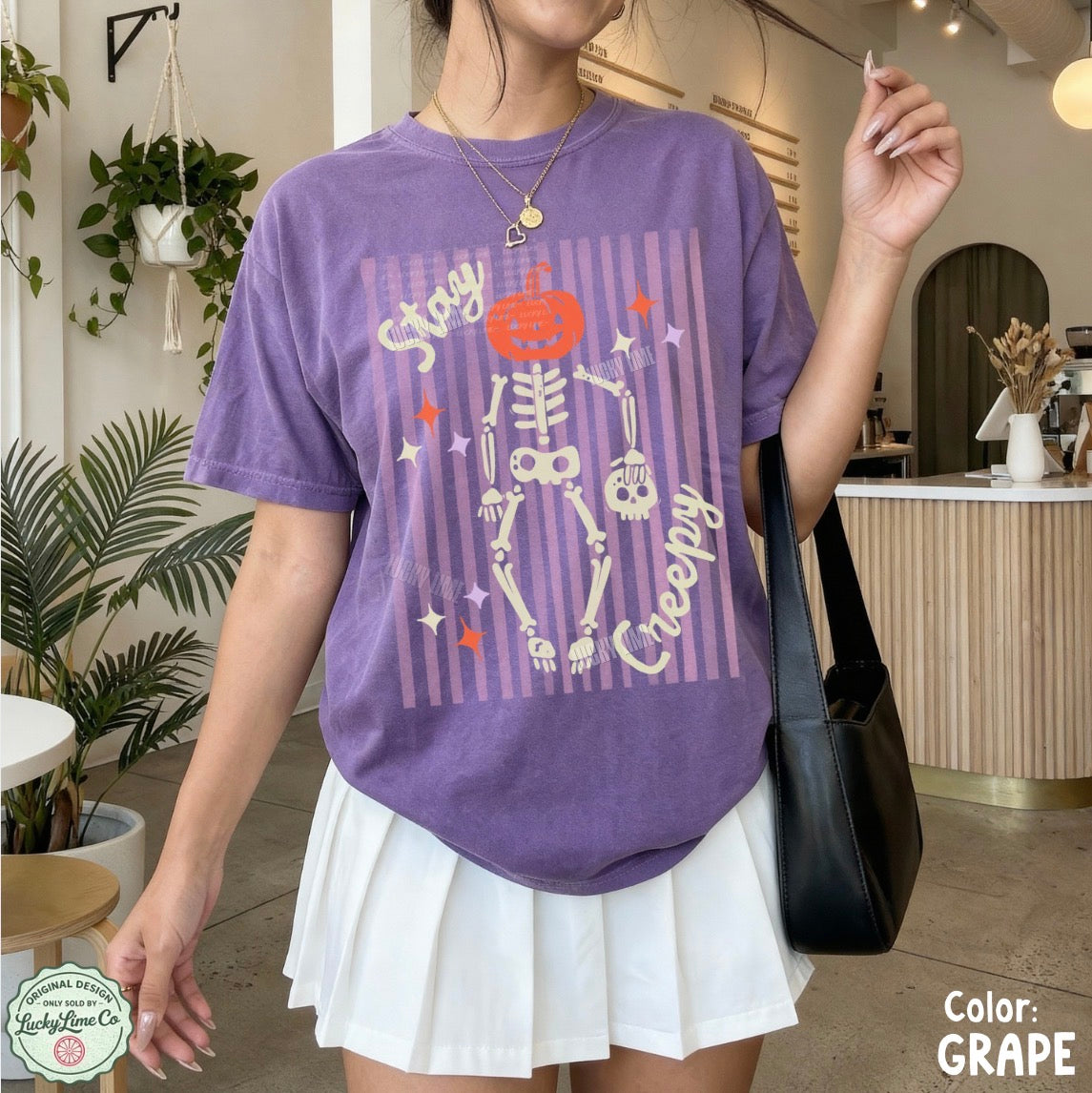 Person wearing a purple Halloween-themed t-shirt with a skeleton design indoors.