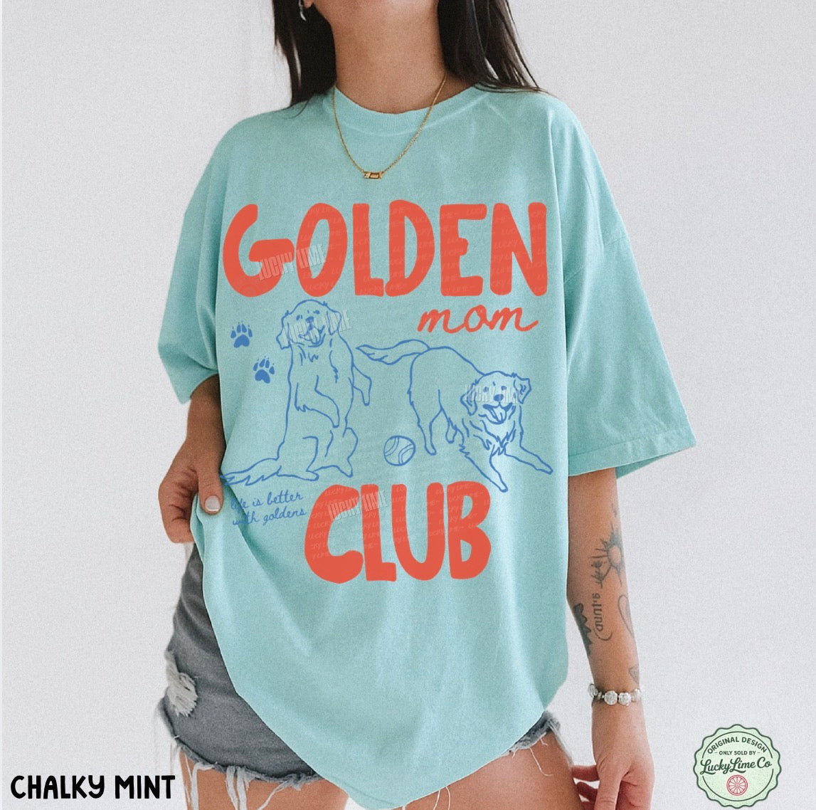 Person wearing a light blue t-shirt with 'Golden Mom Club' text and graphics on a white background