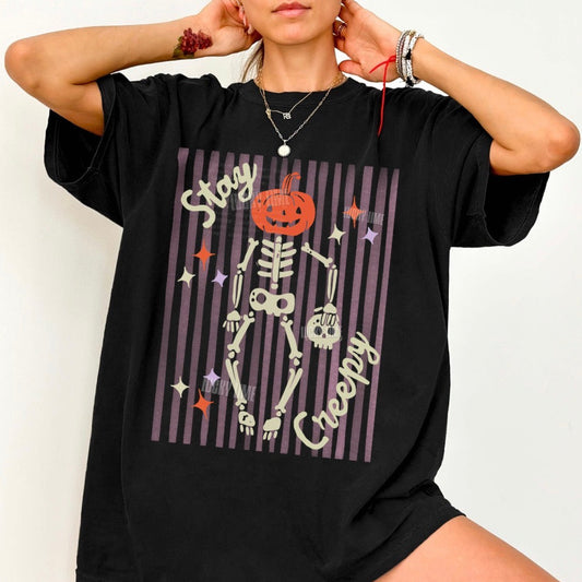 Black oversized t-shirt with skeleton design and text on a white background