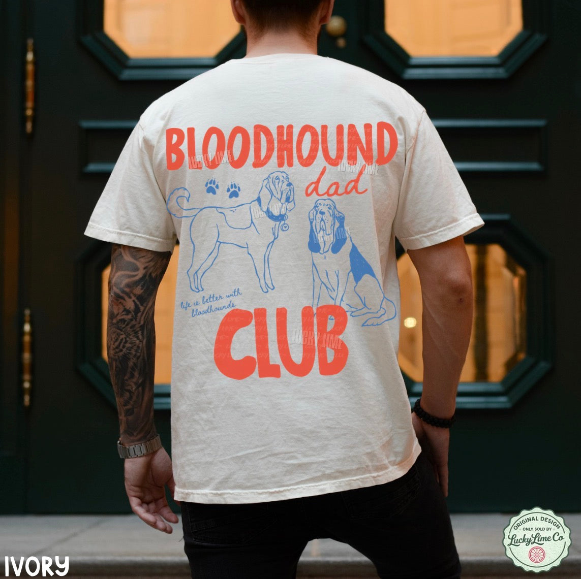 Person wearing a t-shirt with 'Bloodhound Dad Club' design on the back, standing in front of a door.