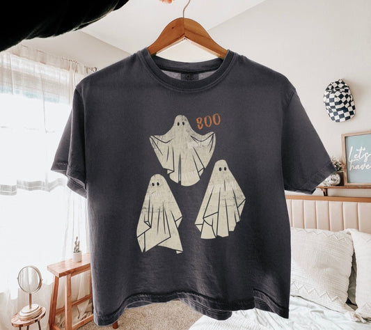 Pepper  t-shirt with ghost design on a hanger in a room.
