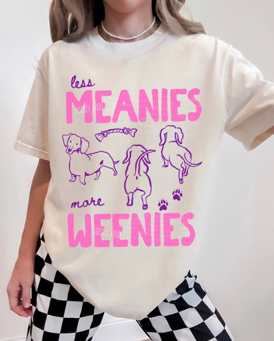 Person wearing a t-shirt with 'less meanies, more weenies' text and dog illustrations.
