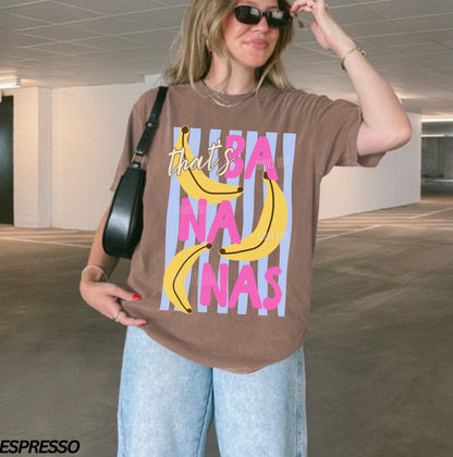 Woman wearing a brown t-shirt with banana graphic and text in an indoor setting
