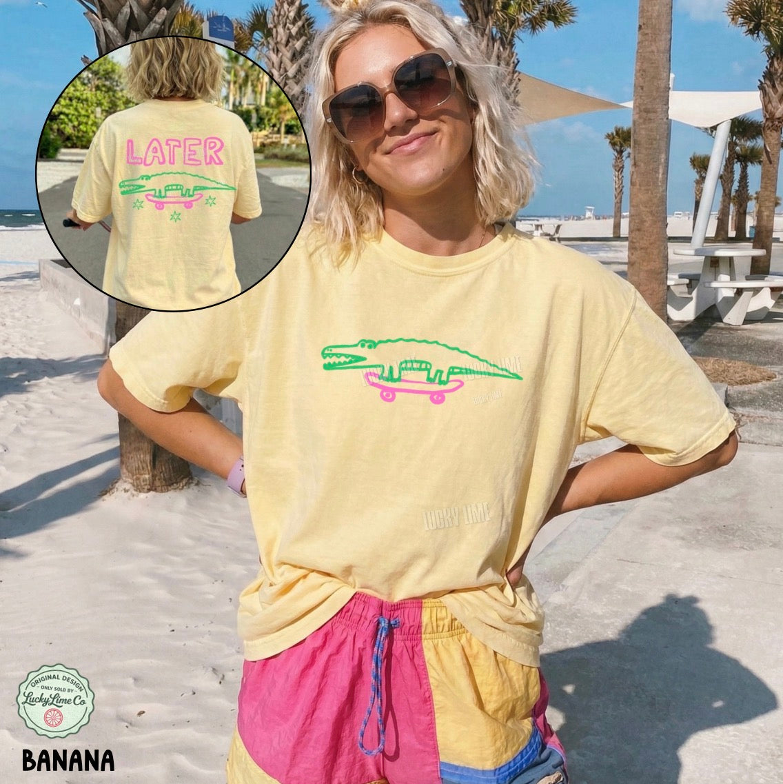 Person wearing a yellow t-shirt with a graphic design, standing on a beach.