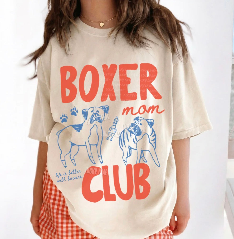 Person wearing a 'Boxer Mom Club' t-shirt with dog illustrations on a white background