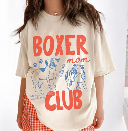 Person wearing a 'Boxer Mom Club' t-shirt with dog illustrations on a white background