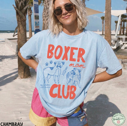 Person wearing a 'Boxer Mom Club' t-shirt on a beach