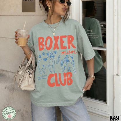 Person wearing a 'French Bulldog Mom' t-shirt holding a drink.