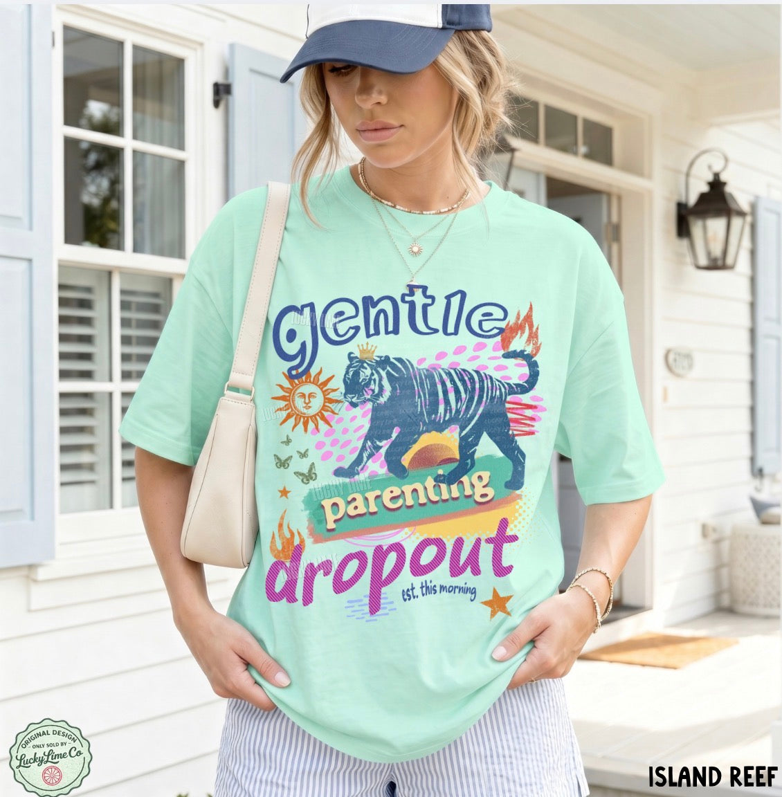 Person wearing a light green t-shirt with a graphic design and text, standing outdoors.