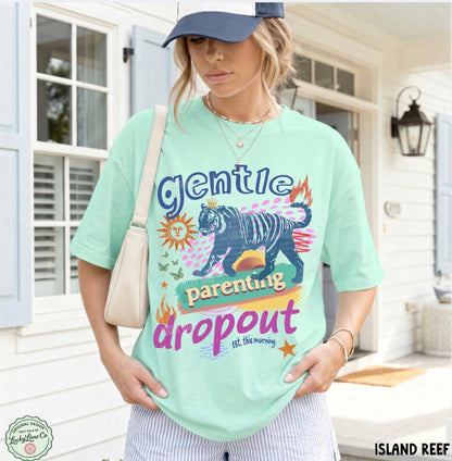 Person wearing a light green t-shirt with a graphic design and text, standing outdoors.
