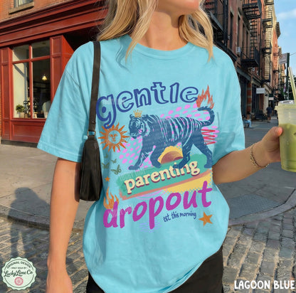 Person wearing a light blue t-shirt with a graphic design and text, standing on a street.