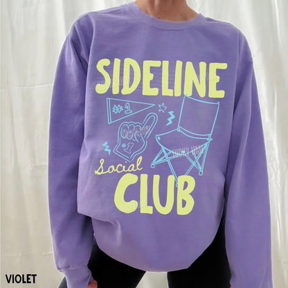 Purple sweatshirt with 'Sideline Social Club' text and graphics on a white background