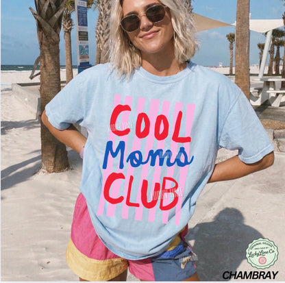Person wearing a 'Cool Moms Club' t-shirt on a beach