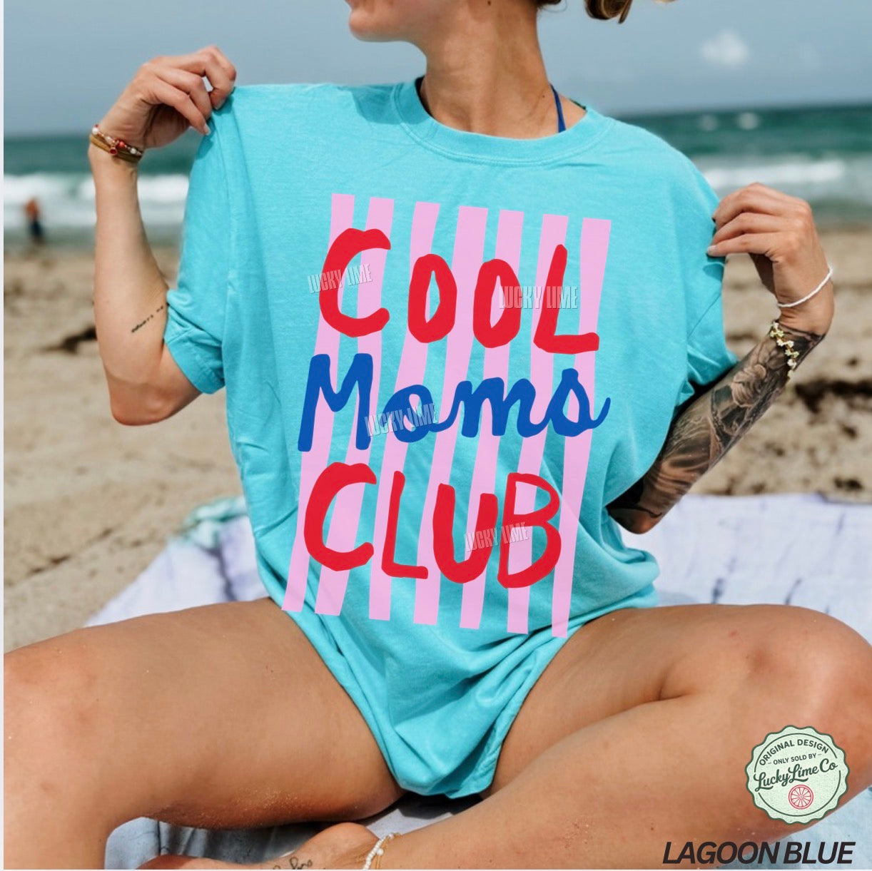 Person wearing a 'Cool Moms Club' t-shirt on a beach