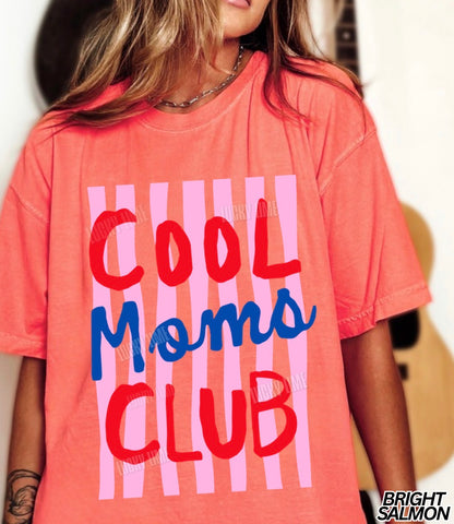 Coral t-shirt with 'Cool Moms Club' text and pink stripes worn by a person.
