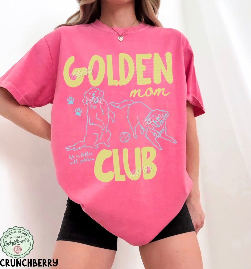 Person wearing a pink t-shirt with 'Golden Mom Club' text and graphics on a white background